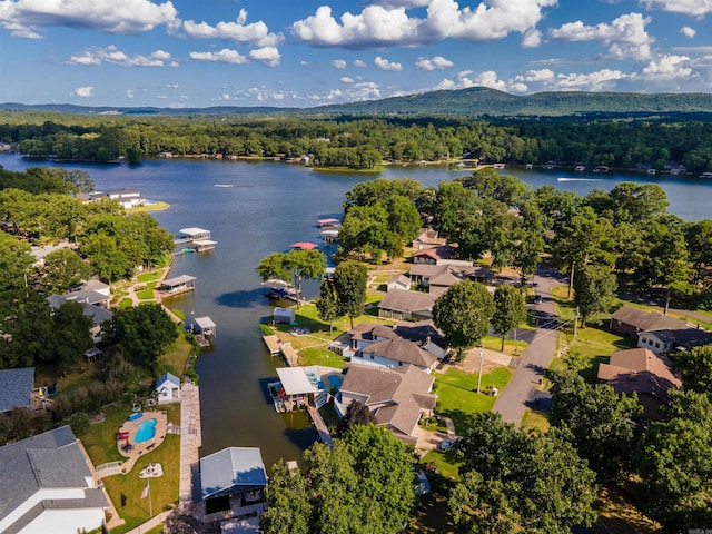 drone / aerial view with a residential view, a water view, and a forest view