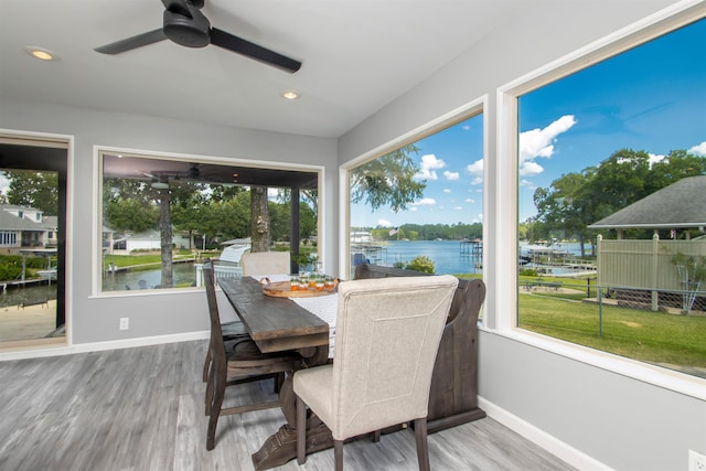 sunroom featuring a water view and ceiling fan