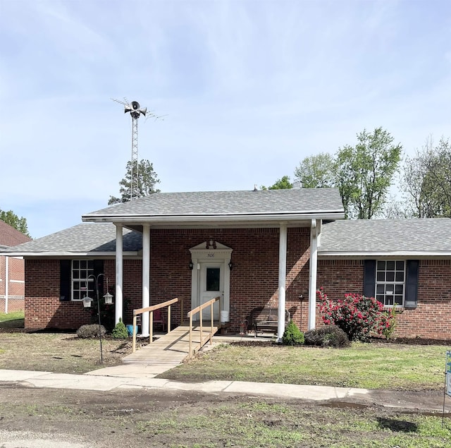 single story home featuring a shingled roof and brick siding