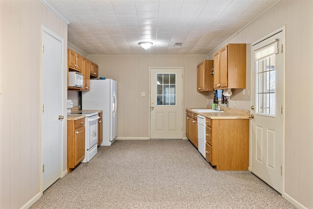 kitchen with light carpet, white appliances, a sink, visible vents, and light countertops