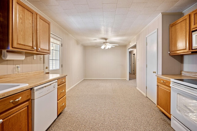 kitchen featuring white appliances, light countertops, and brown cabinetry