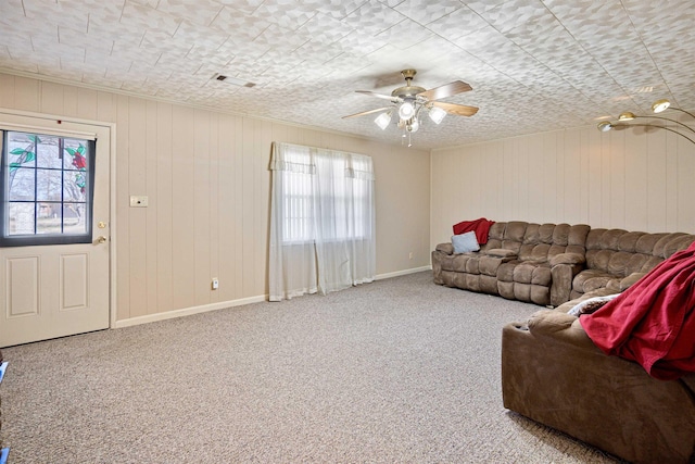 carpeted living room featuring a wealth of natural light, ceiling fan, and baseboards