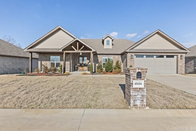 view of front of property featuring driveway, an attached garage, a front lawn, and brick siding