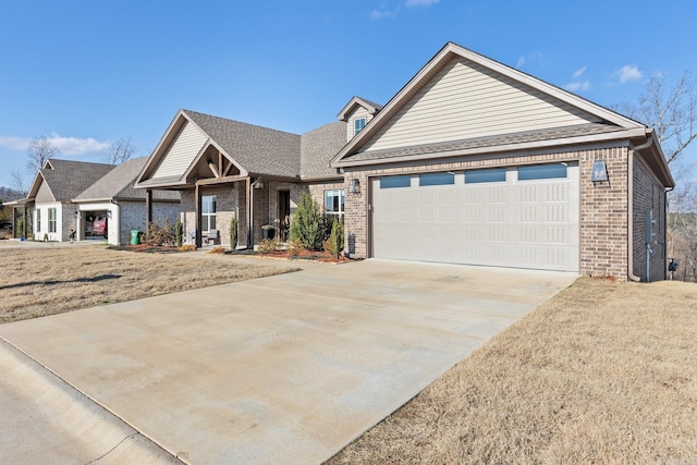 view of front facade with a front yard, brick siding, driveway, and an attached garage