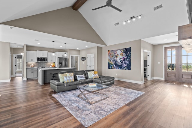 living area featuring baseboards, visible vents, dark wood finished floors, high vaulted ceiling, and beam ceiling