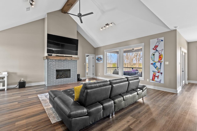 living room featuring dark wood-type flooring, a brick fireplace, and baseboards