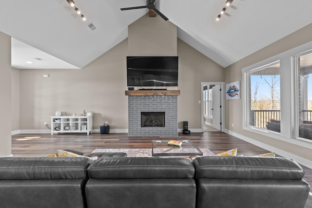 living room with visible vents, a brick fireplace, wood finished floors, high vaulted ceiling, and baseboards