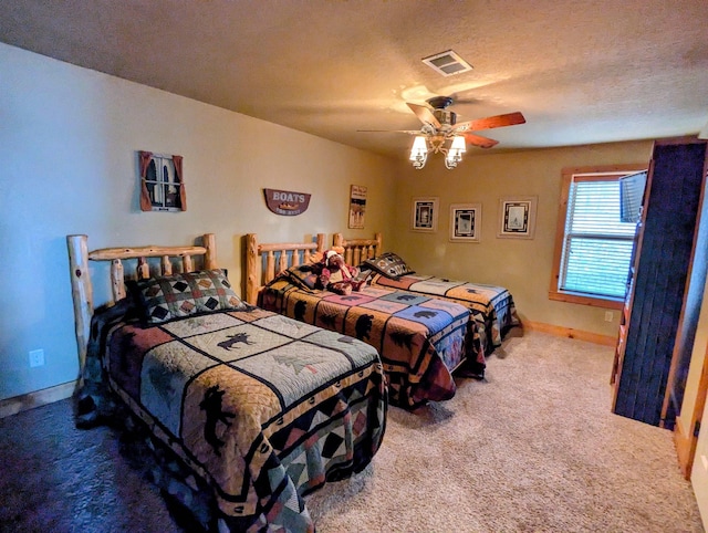 carpeted bedroom with a ceiling fan, visible vents, a textured ceiling, and baseboards