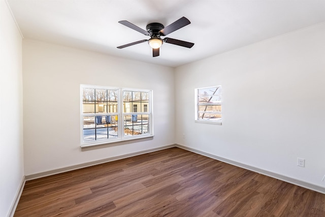 empty room with wood finished floors, a ceiling fan, and baseboards