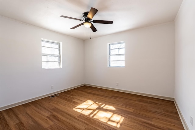 unfurnished room featuring visible vents, ceiling fan, baseboards, and wood finished floors