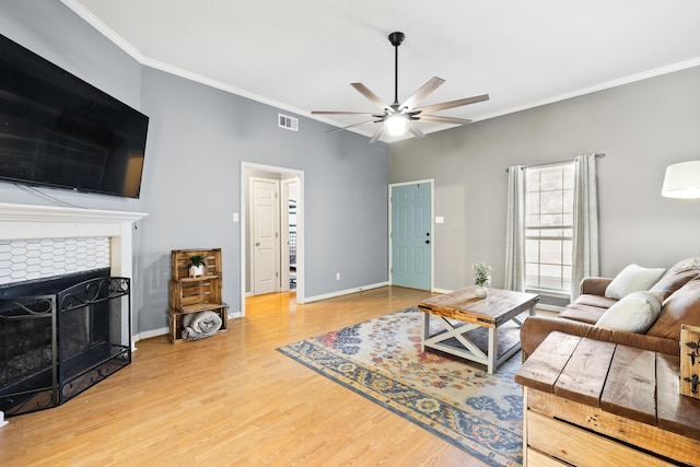 living room with visible vents, crown molding, baseboards, and wood finished floors