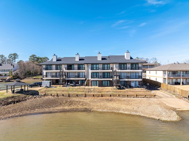 exterior space with a gazebo, a chimney, and a water view