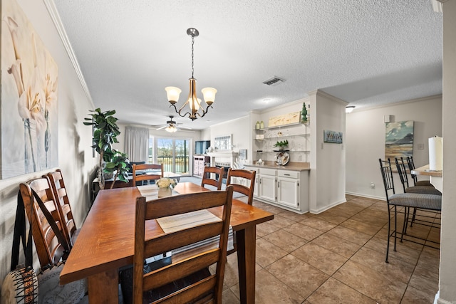 dining area with a fireplace, visible vents, ornamental molding, light tile patterned flooring, and a textured ceiling