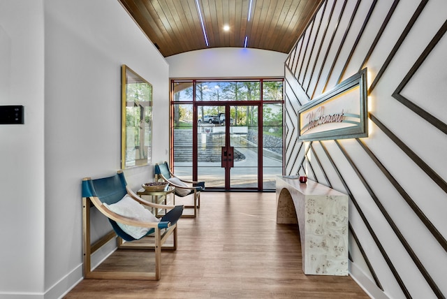 sitting room with baseboards, vaulted ceiling, wood finished floors, and french doors