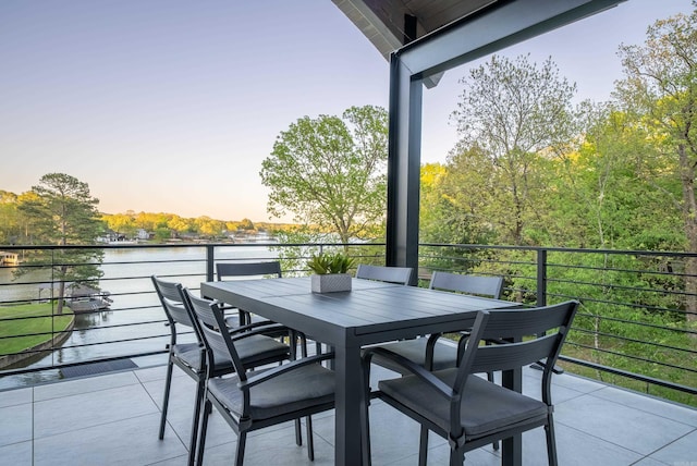 balcony featuring outdoor dining area and a water view