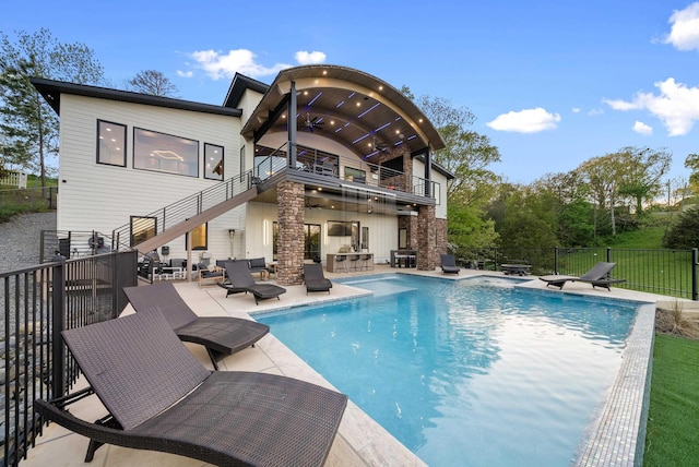 back of property featuring a ceiling fan, a patio, a balcony, stairway, and fence