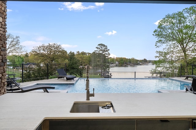 view of pool with a water view, fence, and a fenced in pool