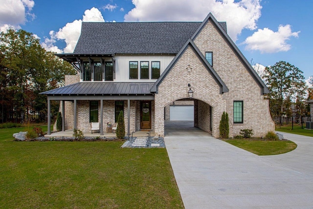 view of front of home with covered porch, concrete driveway, brick siding, and a standing seam roof