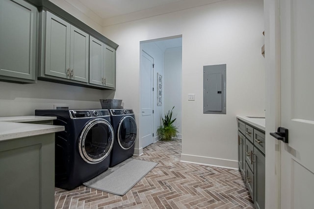 laundry room featuring cabinet space, electric panel, baseboards, independent washer and dryer, and brick floor