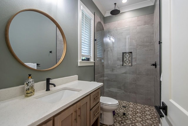 bathroom featuring toilet, a tile shower, and vanity