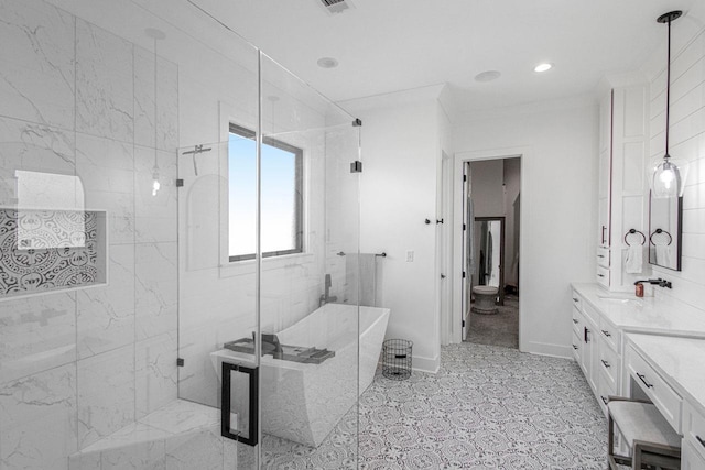 full bathroom featuring ornamental molding, a shower stall, vanity, a freestanding tub, and baseboards