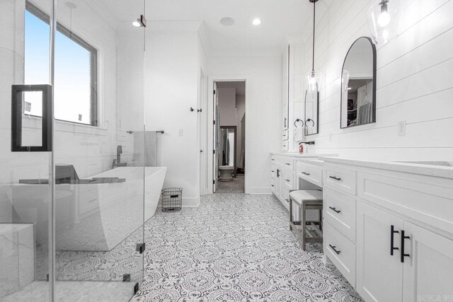 full bath featuring a freestanding bath, a shower stall, vanity, and baseboards