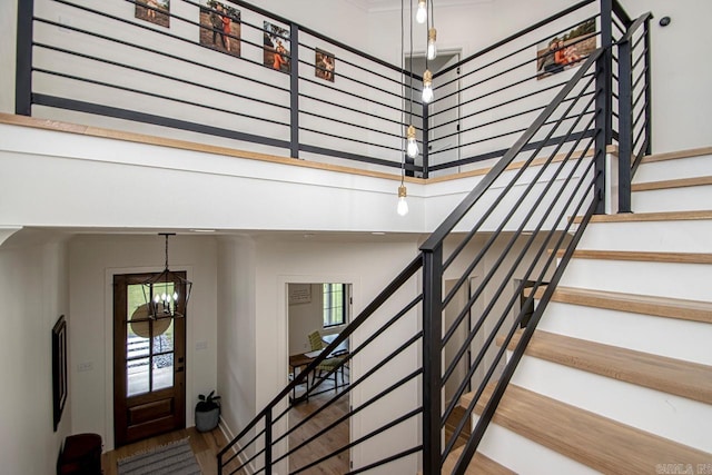 interior space featuring a chandelier, a towering ceiling, and wood finished floors