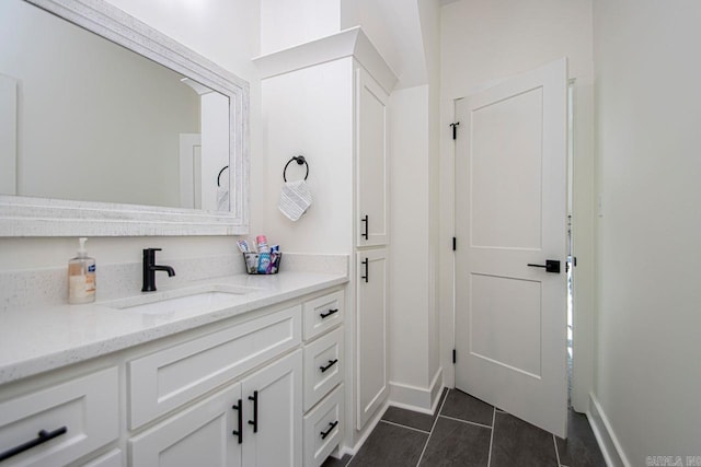 bathroom featuring tile patterned flooring, vanity, and baseboards