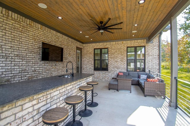 view of patio featuring exterior bar, outdoor lounge area, a sink, and a ceiling fan