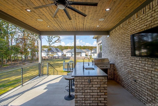 view of patio with outdoor dry bar, grilling area, area for grilling, a sink, and a residential view