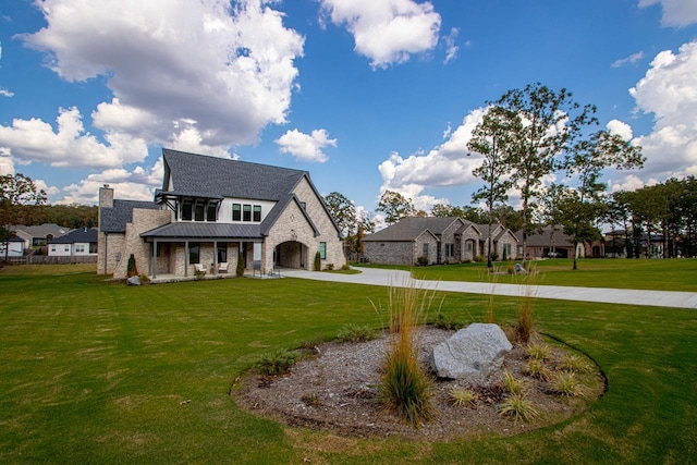 french provincial home with stone siding, a front lawn, and a residential view