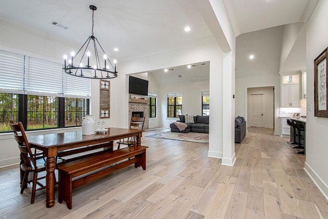 dining area featuring a fireplace, recessed lighting, visible vents, light wood-style flooring, and baseboards