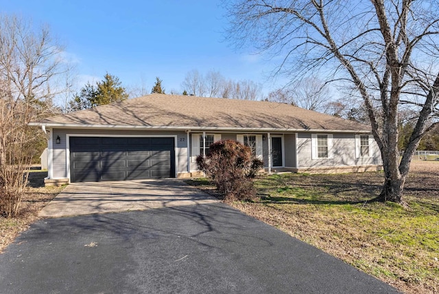 single story home with driveway and an attached garage