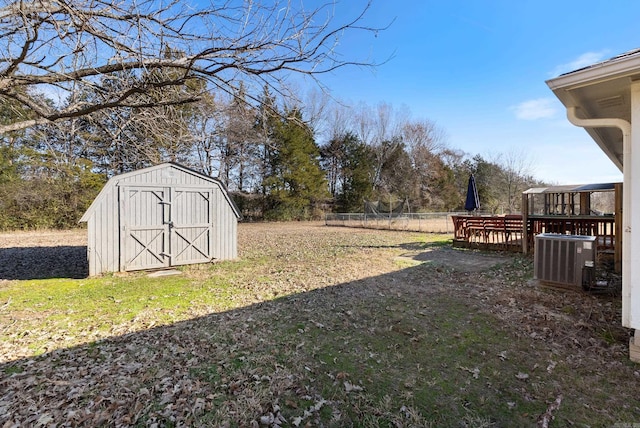 view of yard featuring an outdoor structure, fence, a storage shed, and central air condition unit