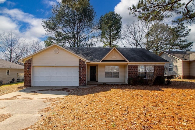 single story home with a garage, concrete driveway, and brick siding