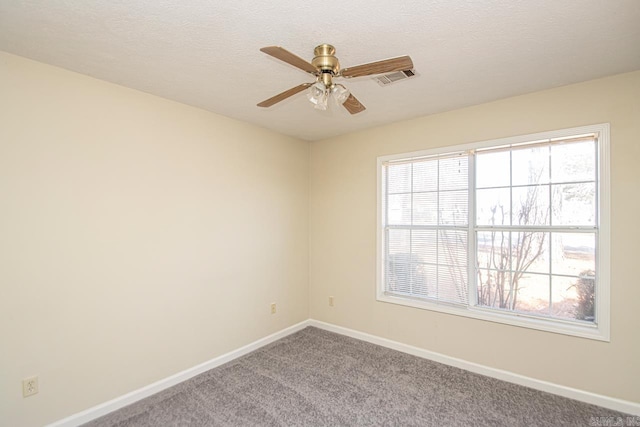 carpeted spare room featuring a textured ceiling, a ceiling fan, visible vents, and baseboards