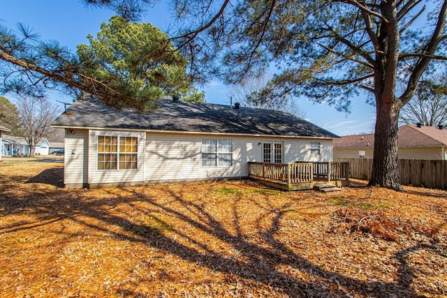 rear view of property with fence, a lawn, and a wooden deck