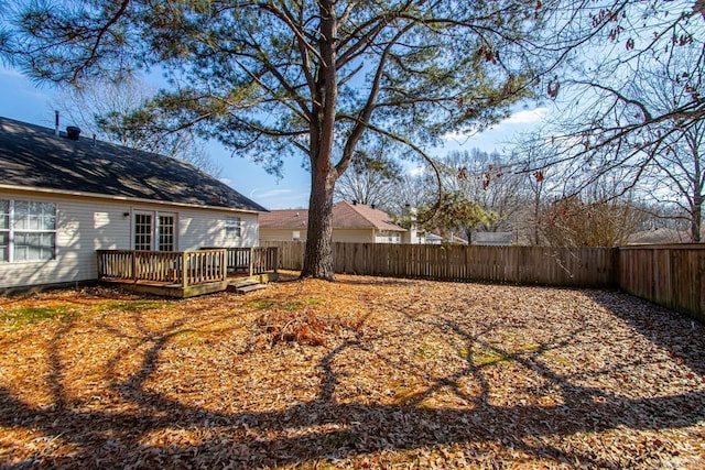 view of yard with a fenced backyard and a wooden deck