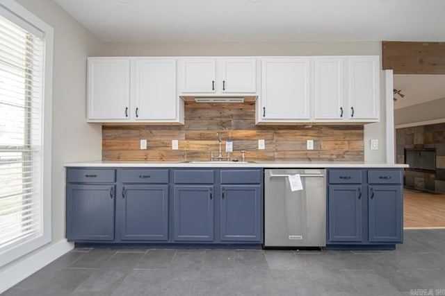 kitchen featuring dishwasher, blue cabinets, light countertops, white cabinetry, and a sink