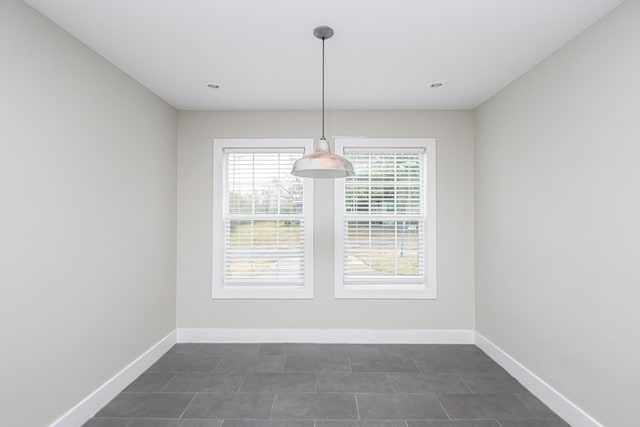 unfurnished dining area with baseboards