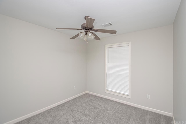 spare room featuring baseboards, visible vents, a ceiling fan, and light colored carpet