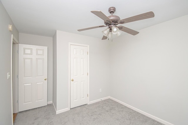 unfurnished bedroom with a ceiling fan, light colored carpet, and baseboards