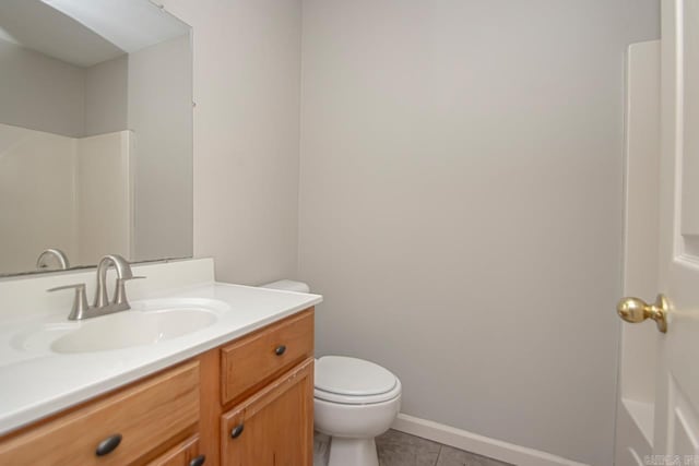 bathroom featuring toilet, vanity, baseboards, tile patterned floors, and walk in shower