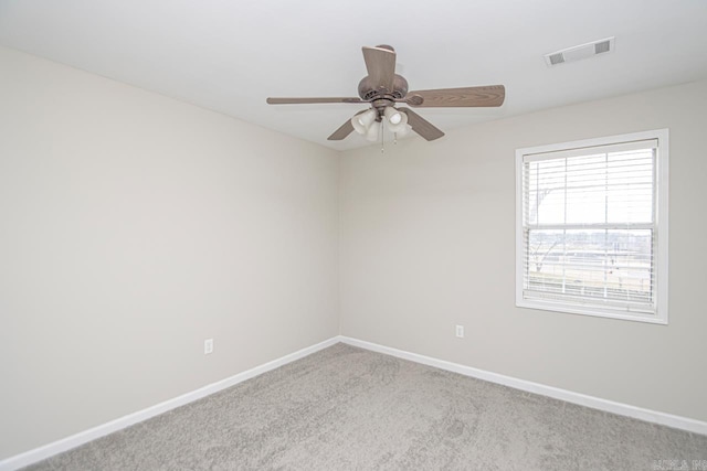 empty room featuring baseboards, ceiling fan, visible vents, and light colored carpet