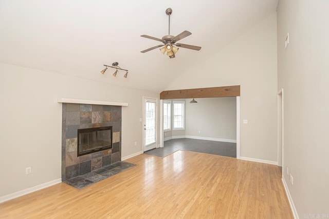 unfurnished living room with a fireplace, wood finished floors, a ceiling fan, and baseboards