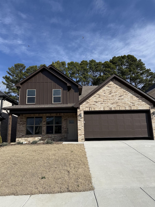 view of front of property with an attached garage, concrete driveway, board and batten siding, and brick siding