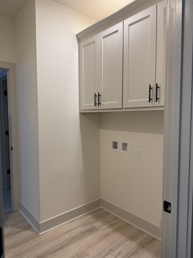 laundry room with light wood-style floors, washer hookup, cabinet space, and baseboards