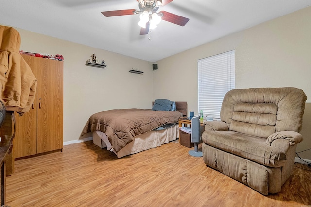 bedroom featuring light wood-style flooring, baseboards, and ceiling fan