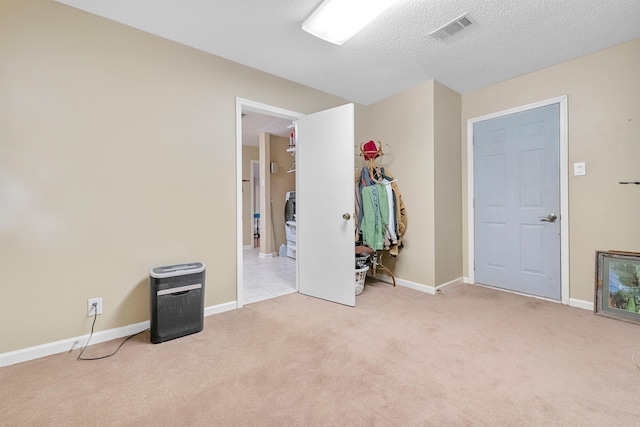 bedroom with baseboards, visible vents, a textured ceiling, and light colored carpet