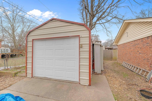 detached garage featuring fence